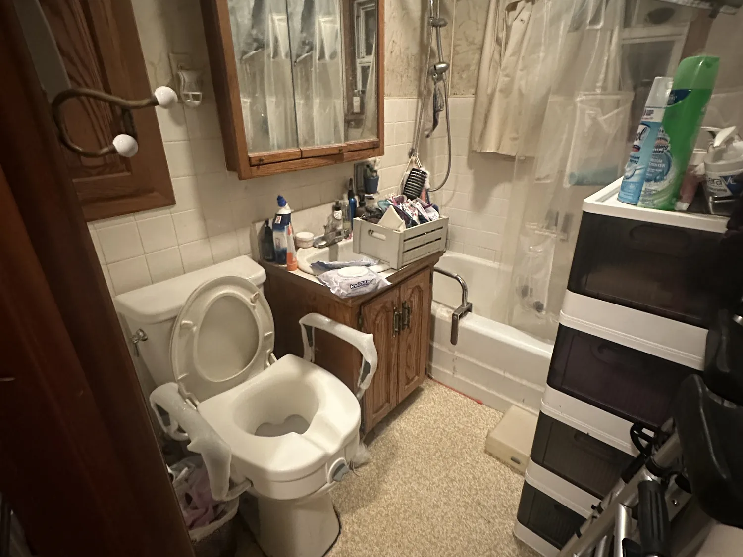 Dated, cramped bathroom before remodeling, with old fixtures and a mobility walker