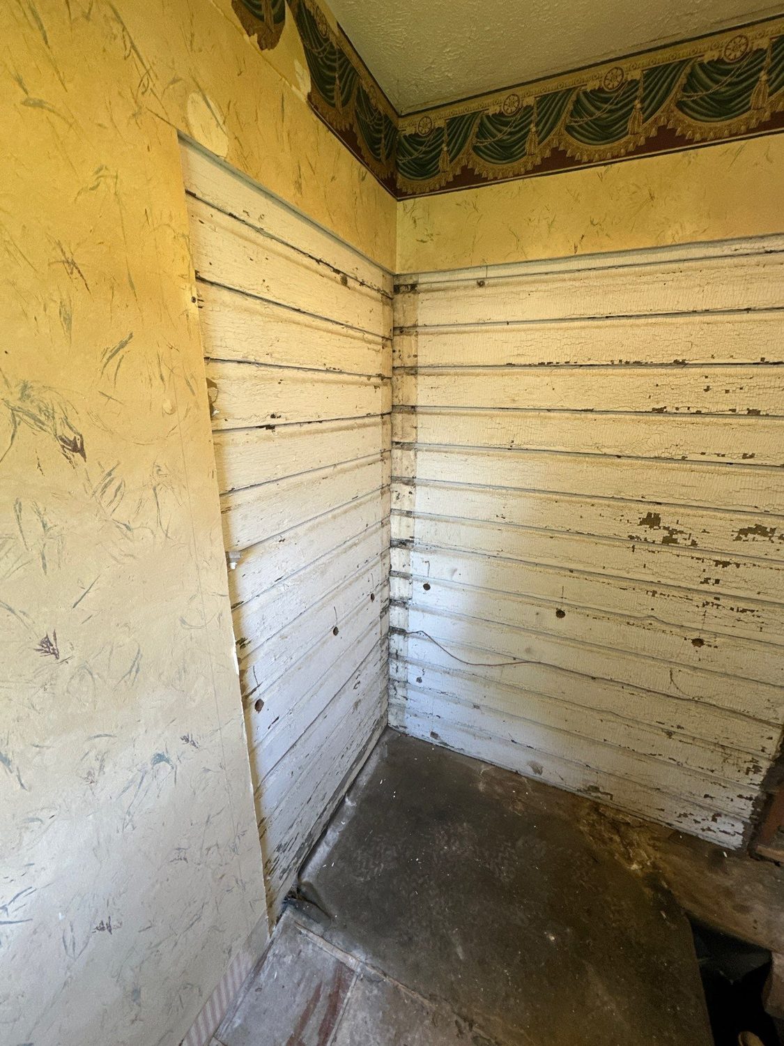 Bathroom stripped back to the original plank sheathing and bare subfloor during demolition