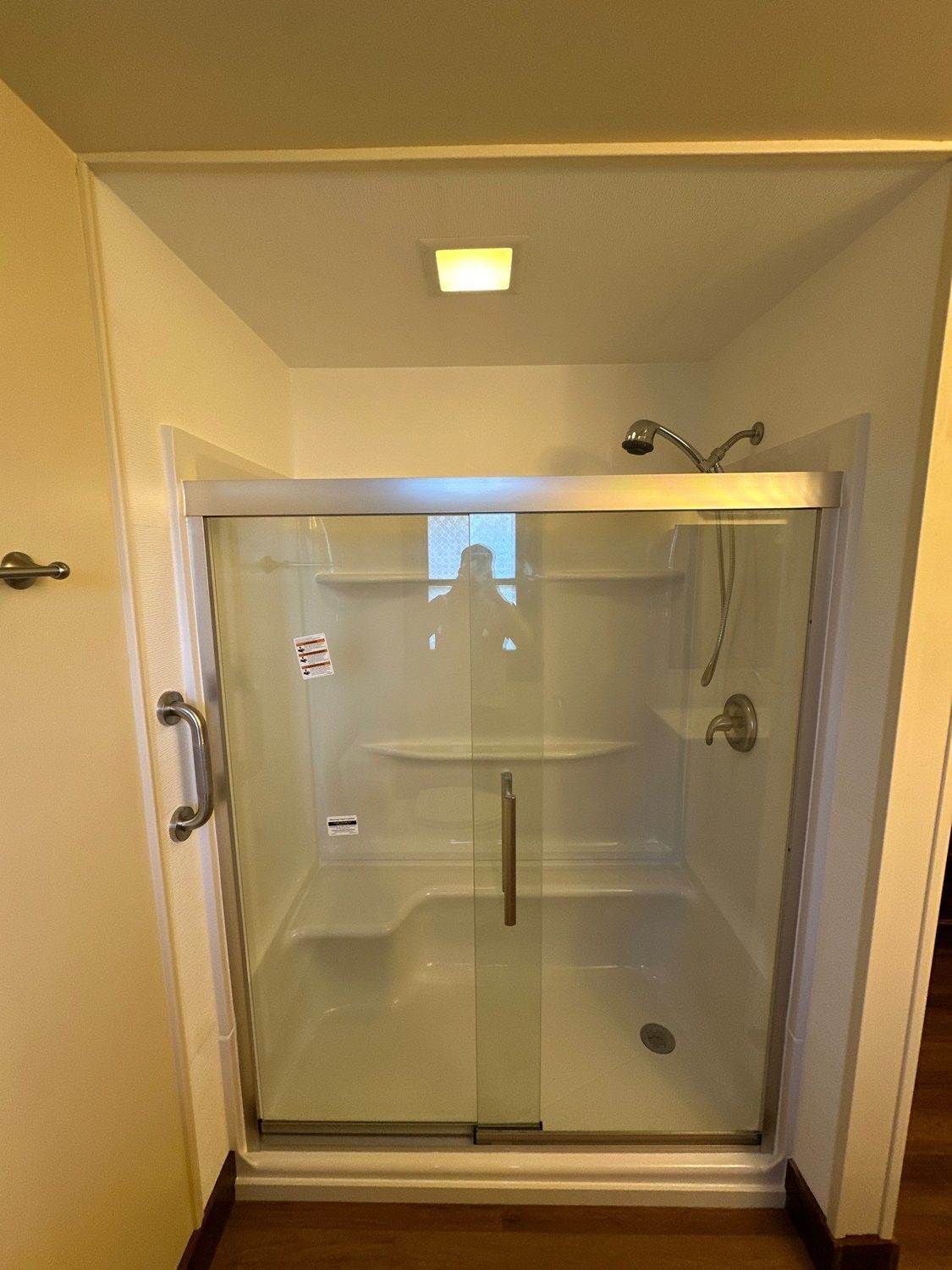 Finished shower with sliding glass doors, brushed nickel fixtures, and fresh paint