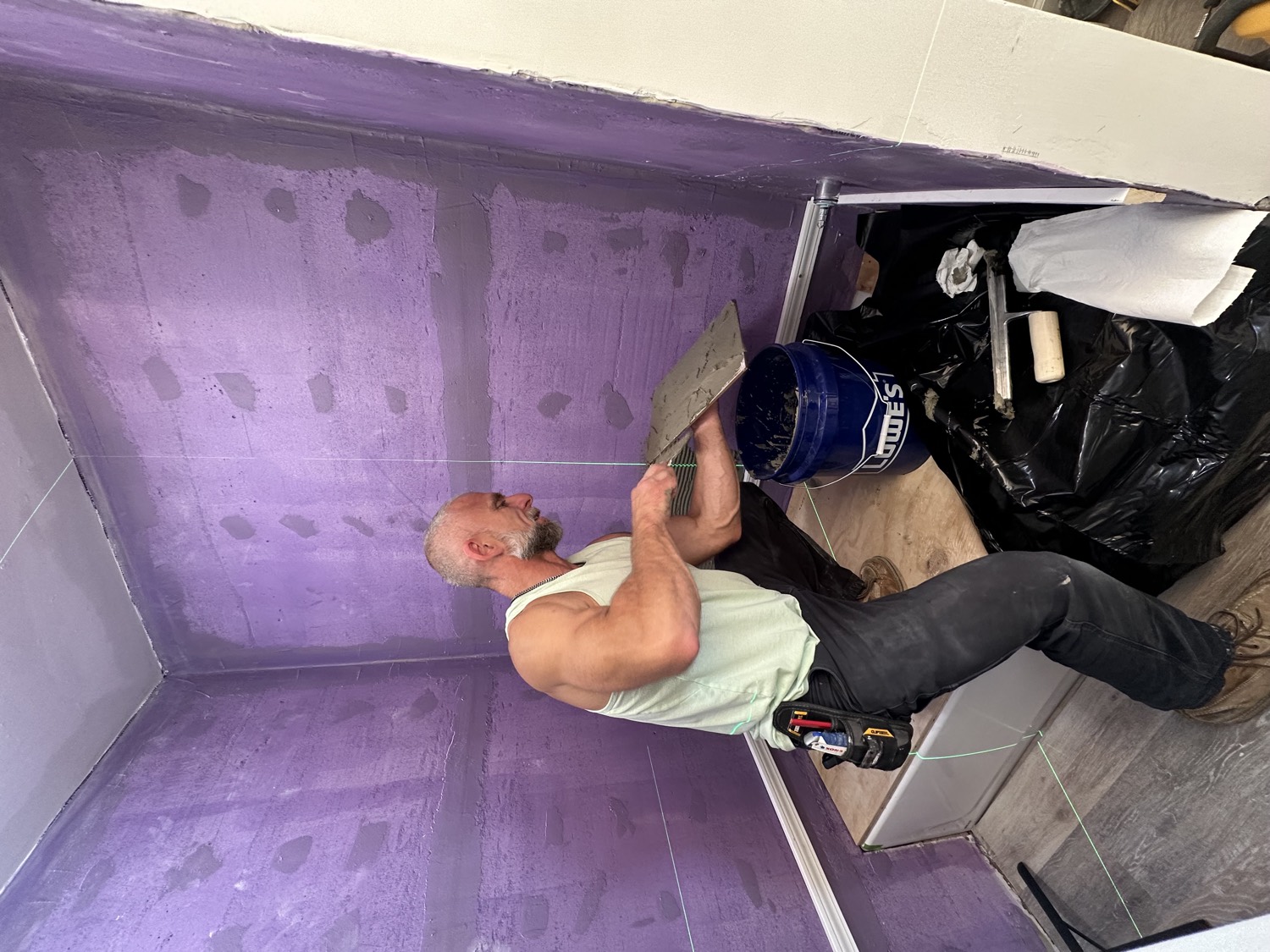 Say When Contracting craftsman applying waterproofing membrane to a shower before tiling