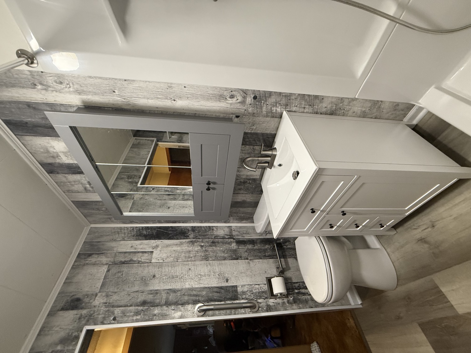 New vanity and mirror against a rustic gray plank wall
