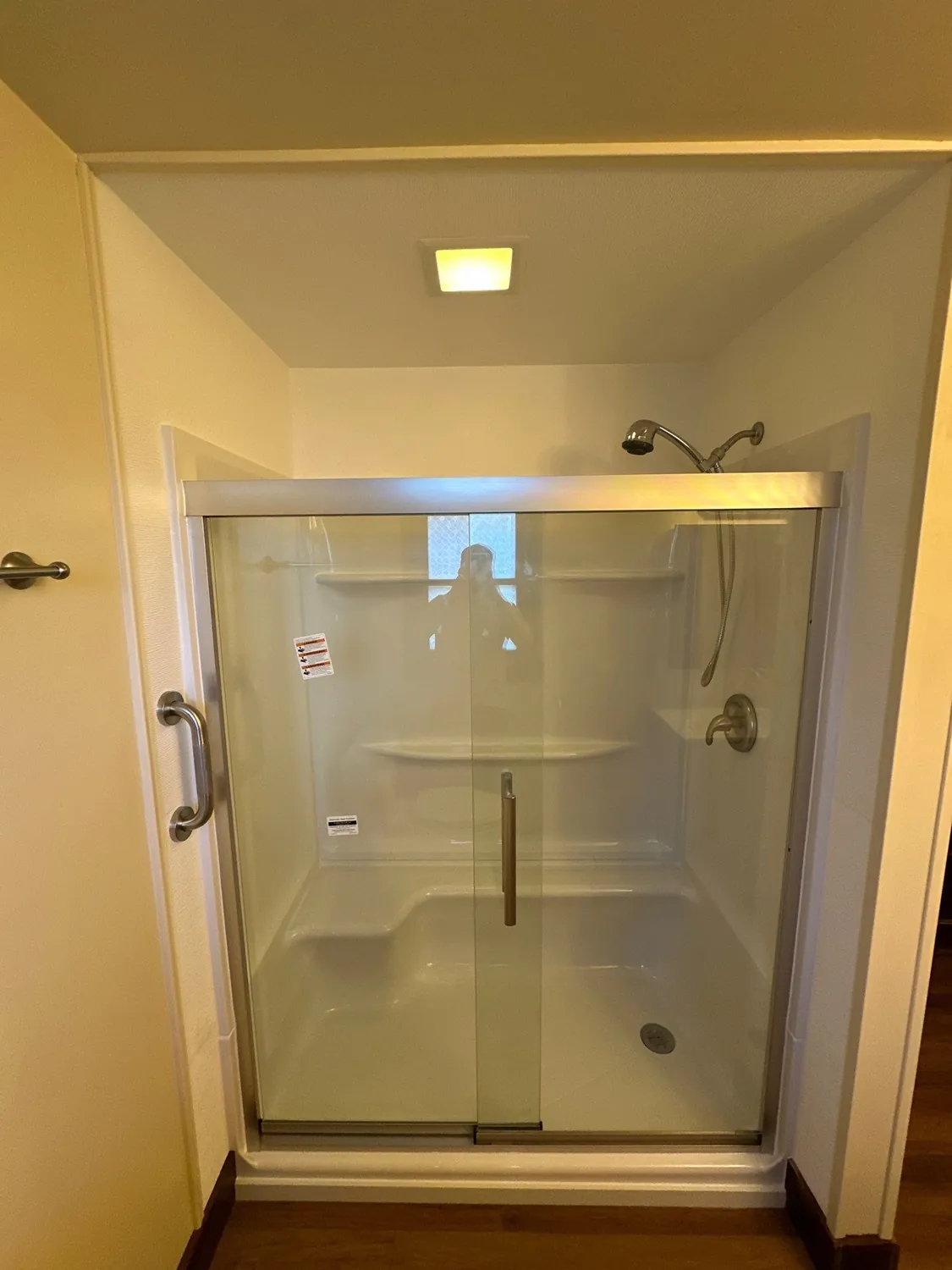 Finished shower with sliding glass doors, brushed nickel fixtures, and fresh paint