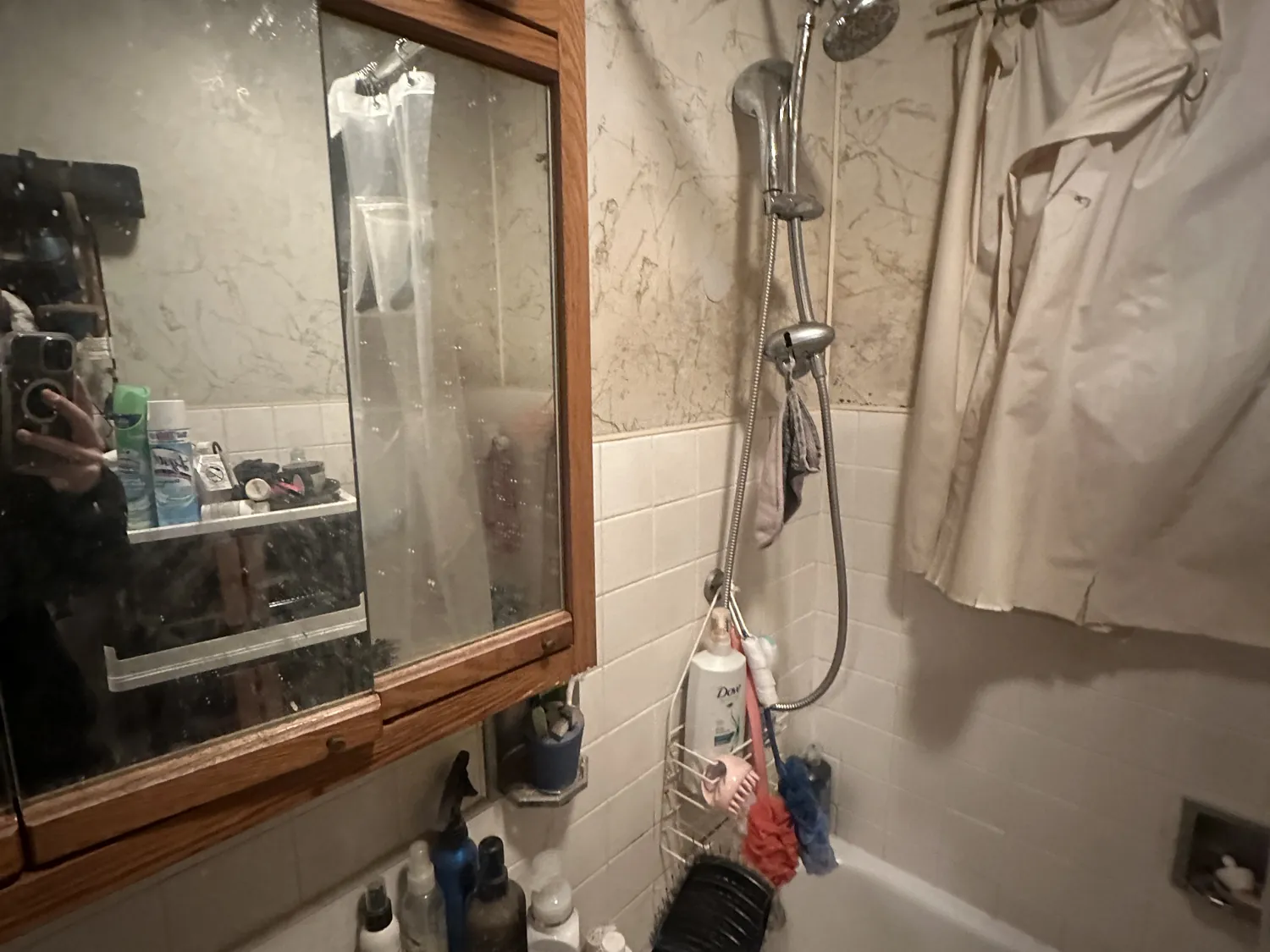 Old, cluttered bathroom with dated vanity and fixtures before remodeling