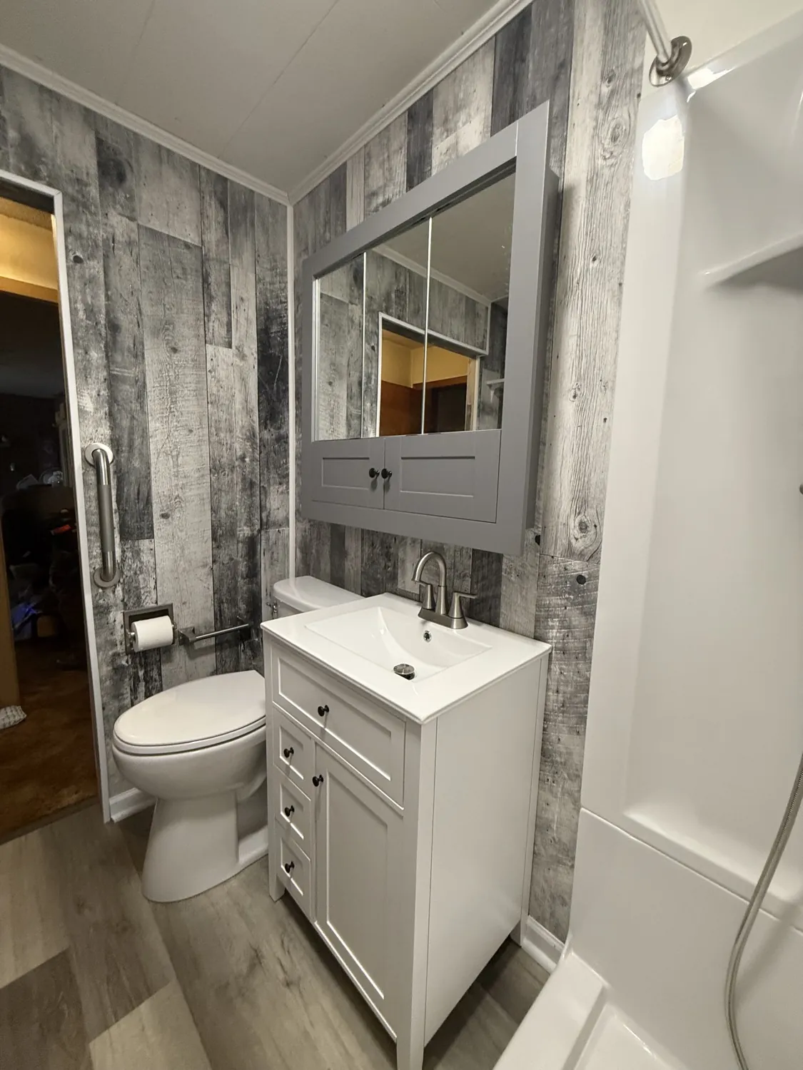 New vanity and mirror against a rustic gray plank wall